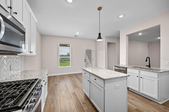 3031 Sunmoon Ln, Katy, TX 77493 - kitchen with a sink, a kitchen island, stainless steel appliances, and light wood finished floors