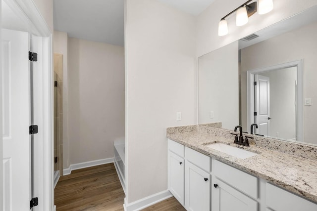 3031 Sunmoon Ln, Katy, TX 77493 - bathroom with vanity, a shower, wood finished floors, a washtub, and baseboards