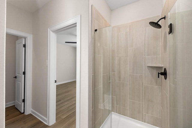 3031 Sunmoon Ln, Katy, TX 77493 - bathroom with baseboards, wood finished floors, and a tile shower