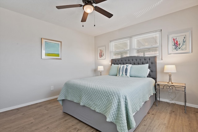 bedroom featuring a ceiling fan, baseboards, and wood finished floors
