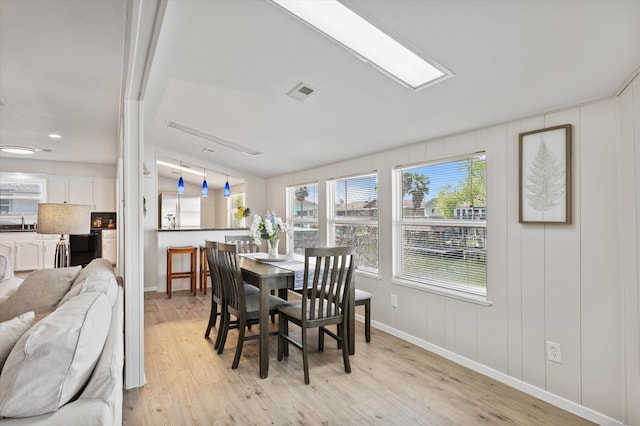 dining area with baseboards, visible vents, and light wood-type flooring