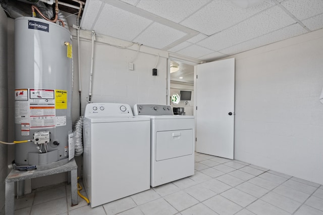 clothes washing area featuring washing machine and clothes dryer, concrete block wall, laundry area, and gas water heater