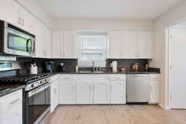 kitchen featuring a sink, appliances with stainless steel finishes, white cabinets, and light wood finished floors