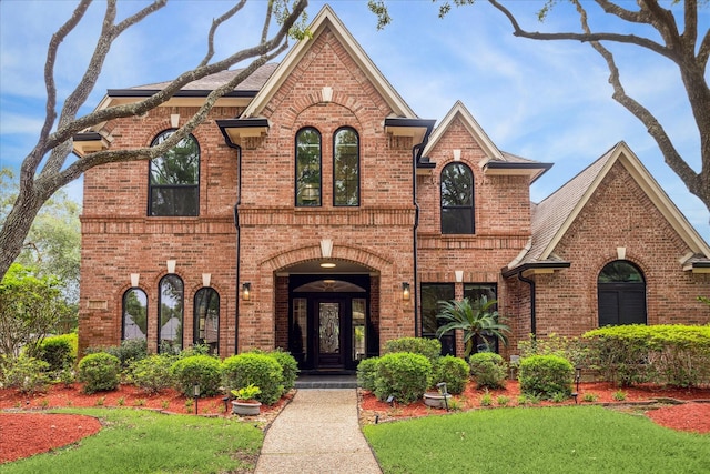 view of front of home with brick siding and a front lawn
