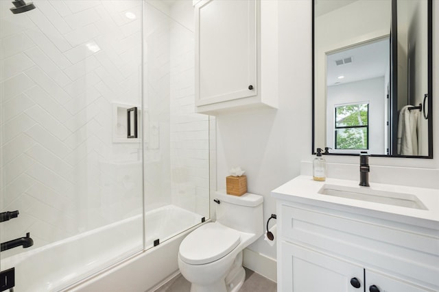 bathroom with vanity, visible vents, toilet, baseboards, and combined bath / shower with glass door