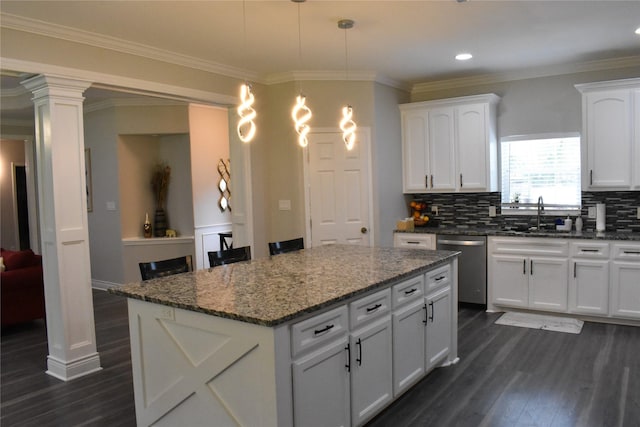 kitchen with tasteful backsplash, stainless steel dishwasher, a sink, white cabinets, and dark wood-type flooring