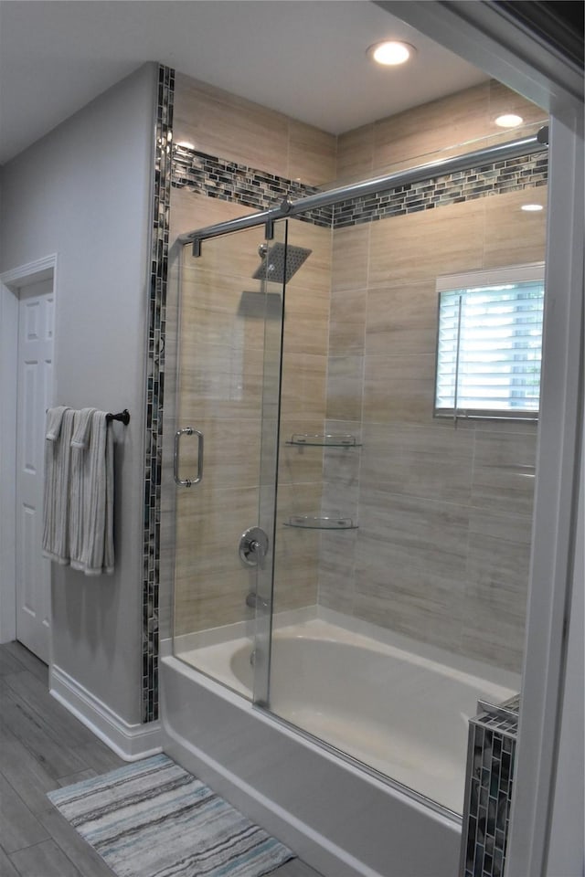 bathroom with recessed lighting, combined bath / shower with glass door, and wood finished floors
