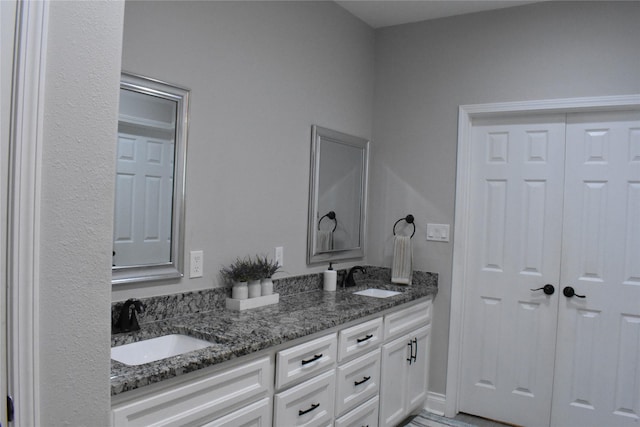 full bathroom with double vanity and a sink