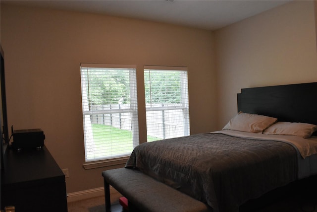 bedroom with carpet flooring, baseboards, and multiple windows