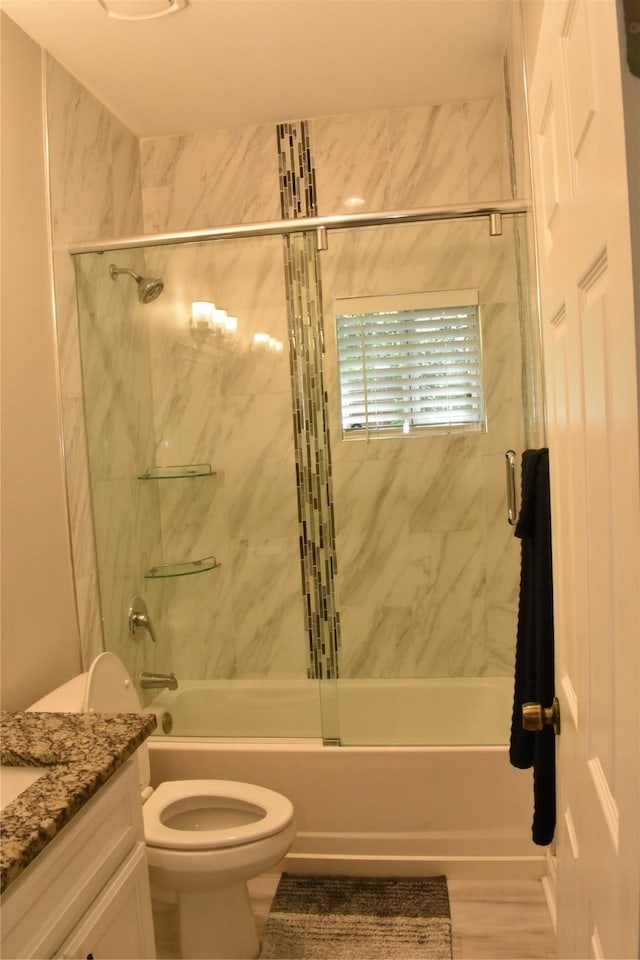 full bathroom with shower / bath combination with glass door, toilet, and vanity
