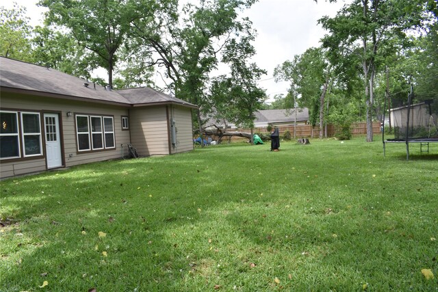 view of yard with fence and a trampoline