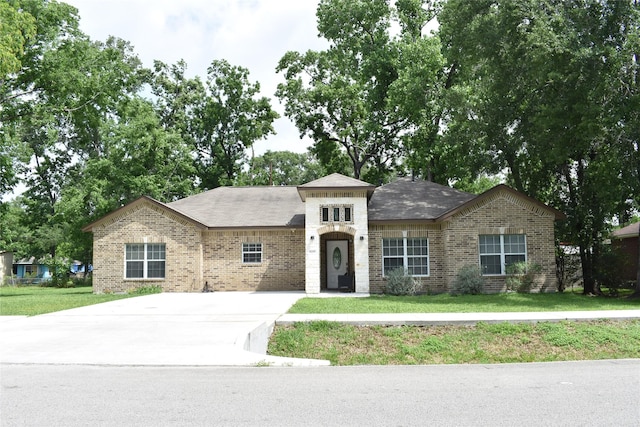 view of front of property featuring brick siding, a front yard, and concrete driveway