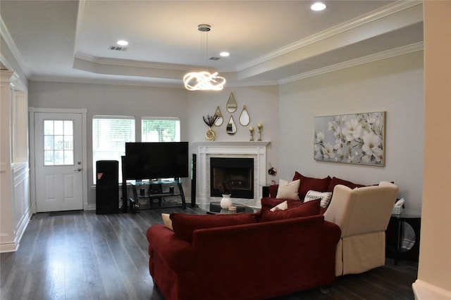 living room featuring crown molding, a fireplace with flush hearth, a raised ceiling, and dark wood-style flooring