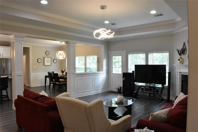 living room with visible vents, an inviting chandelier, decorative columns, a decorative wall, and dark wood finished floors