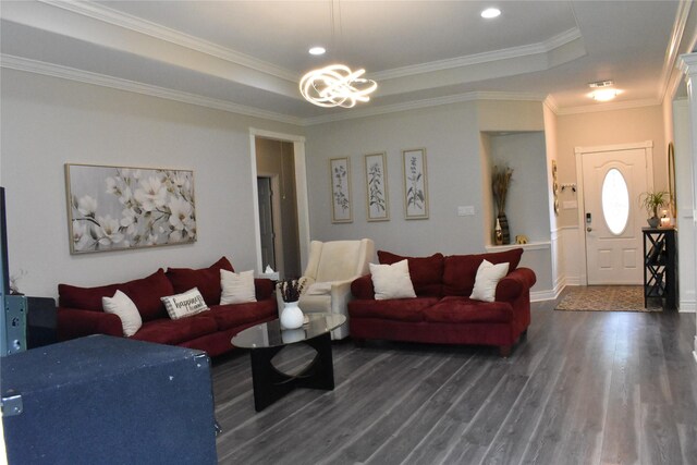living area featuring an inviting chandelier, a raised ceiling, crown molding, and dark wood-style floors