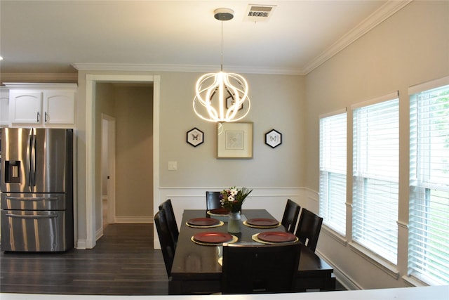 dining space with dark wood-style flooring, a notable chandelier, wainscoting, visible vents, and ornamental molding
