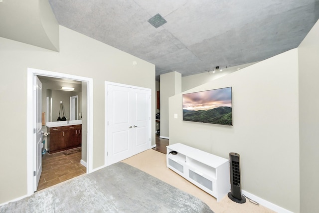 interior space with baseboards, a closet, and ensuite bath