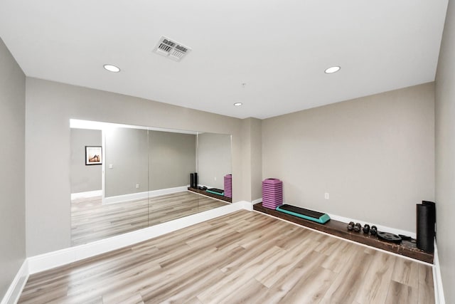 workout room with baseboards, recessed lighting, wood finished floors, and visible vents