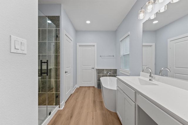 12341 N Chestnut Hills Dr, Conroe, TX 77303 - full bathroom with a freestanding bath, a shower stall, wood finished floors, and vanity