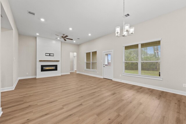 12341 N Chestnut Hills Dr, Conroe, TX 77303 - unfurnished living room featuring baseboards, visible vents, ceiling fan with notable chandelier, and light wood-style floors