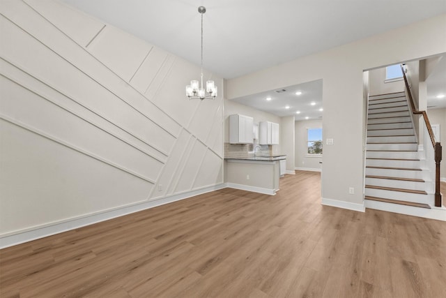 12341 N Chestnut Hills Dr, Conroe, TX 77303 - unfurnished dining area with a chandelier, light wood-style flooring, stairs, recessed lighting, and baseboards