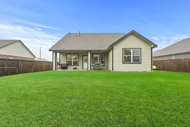 12341 N Chestnut Hills Dr, Conroe, TX 77303 - back of house with a fenced backyard, a shingled roof, and a lawn