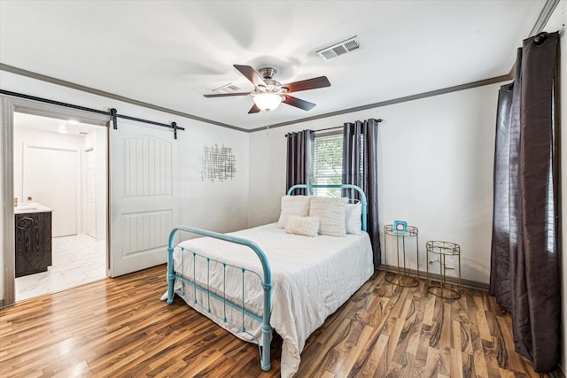 1602 Libbey Dr, Houston, TX 77018 - bedroom featuring a barn door, ornamental molding, wood finished floors, ceiling fan, and baseboards