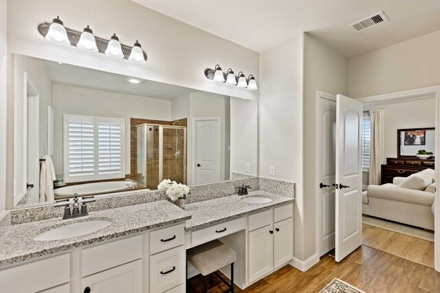 full bathroom with visible vents, a shower stall, a bath, and plenty of natural light