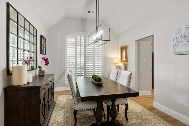 dining room featuring baseboards, lofted ceiling, light wood-type flooring, and visible vents