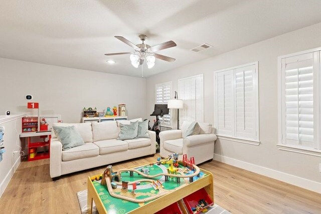 game room with ceiling fan, visible vents, baseboards, and light wood-type flooring