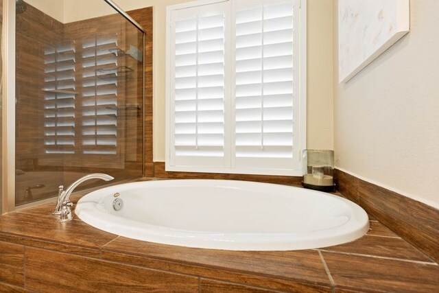 full bath featuring a shower stall and a bath