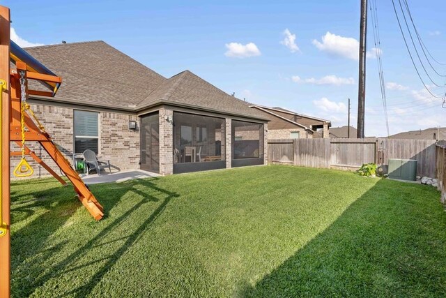 view of yard with a sunroom and a fenced backyard