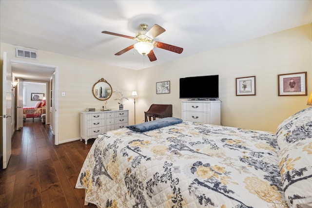 bedroom with visible vents, a ceiling fan, dark wood finished floors, and baseboards
