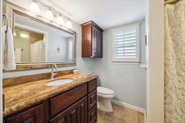 full bathroom with baseboards, vanity, and toilet