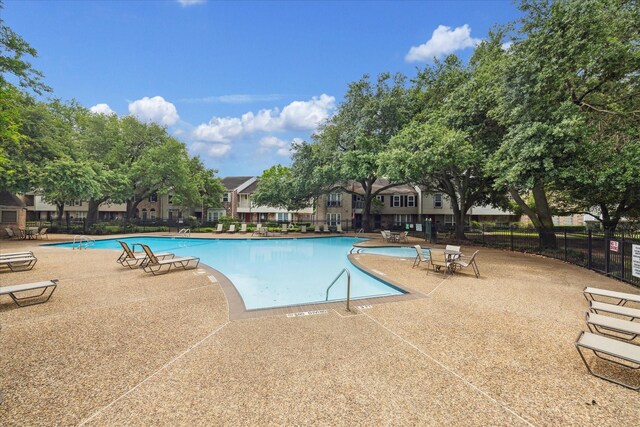 community pool featuring a patio area and fence