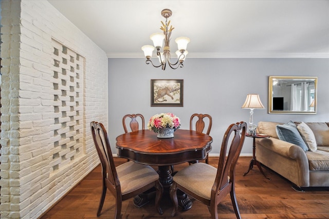 dining area with an inviting chandelier, ornamental molding, baseboards, and dark wood-style floors