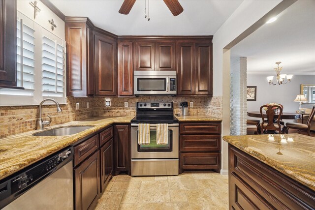 kitchen with stainless steel appliances, light stone countertops, decorative backsplash, and a sink