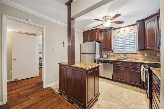 kitchen featuring a sink, appliances with stainless steel finishes, ornamental molding, and ceiling fan