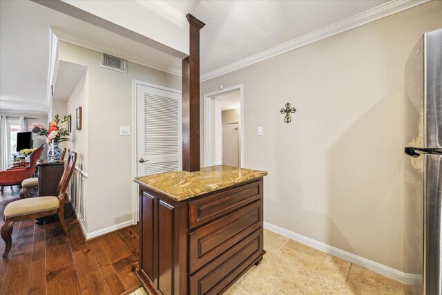 hallway with baseboards, visible vents, and ornamental molding
