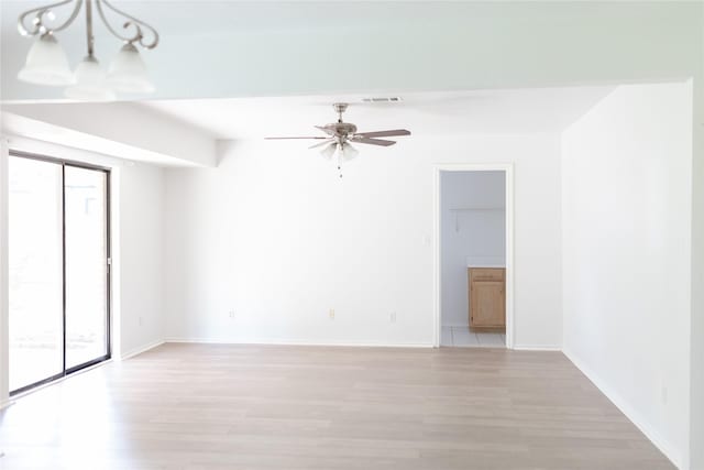 unfurnished room with ceiling fan, light wood-style flooring, baseboards, and visible vents