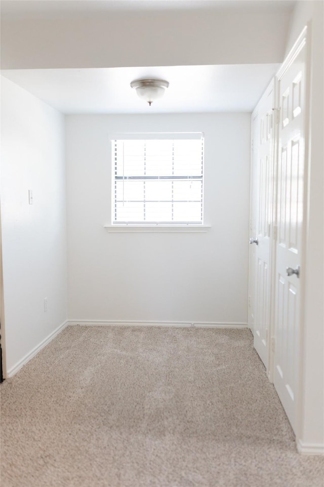 carpeted empty room with baseboards