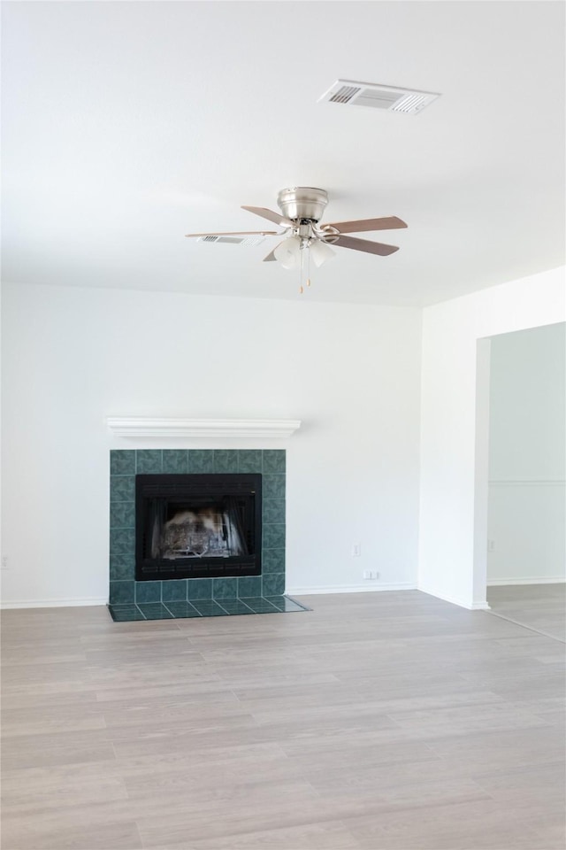 interior details with a fireplace, baseboards, visible vents, and wood finished floors