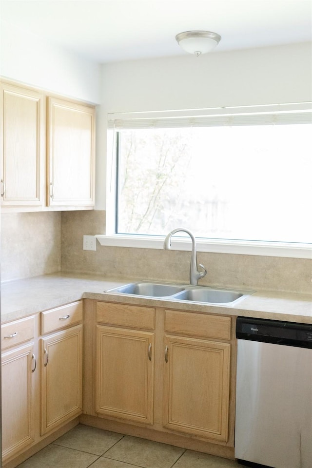 kitchen featuring a sink, stainless steel dishwasher, light brown cabinetry, and light countertops