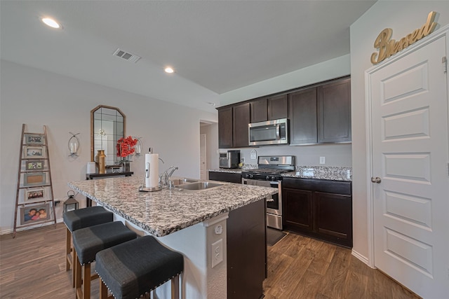 3923 Hawaiian Ct, Baytown, TX 77521 - kitchen with appliances with stainless steel finishes, a sink, dark wood-style floors, dark brown cabinetry, and recessed lighting