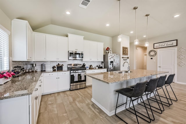 4711 Bartagrass Dr, Rosenberg, TX 77469 - kitchen with appliances with stainless steel finishes, a sink, light wood-style flooring, decorative backsplash, and visible vents