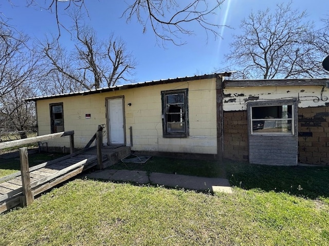 view of front of home with concrete block siding and a front yard