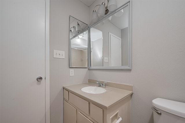 half bathroom featuring vanity and toilet