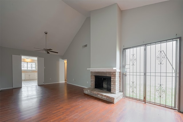 unfurnished living room featuring high vaulted ceiling, a ceiling fan, wood finished floors, and visible vents
