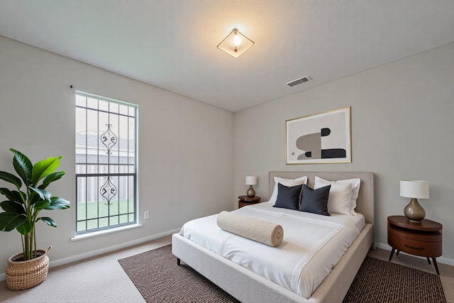 bedroom with carpet floors, baseboards, and multiple windows