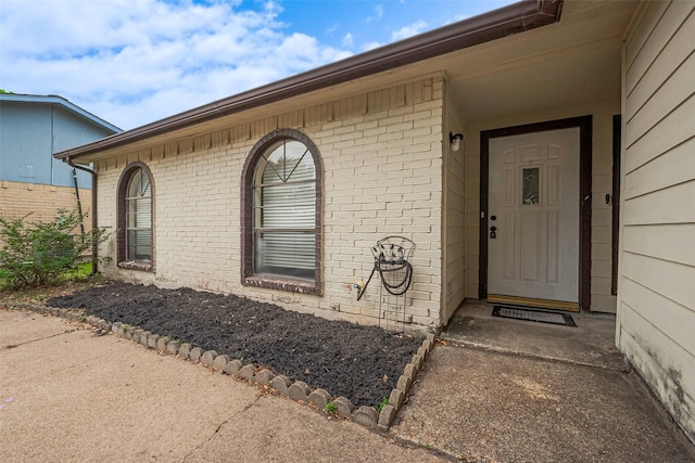 view of exterior entry with brick siding